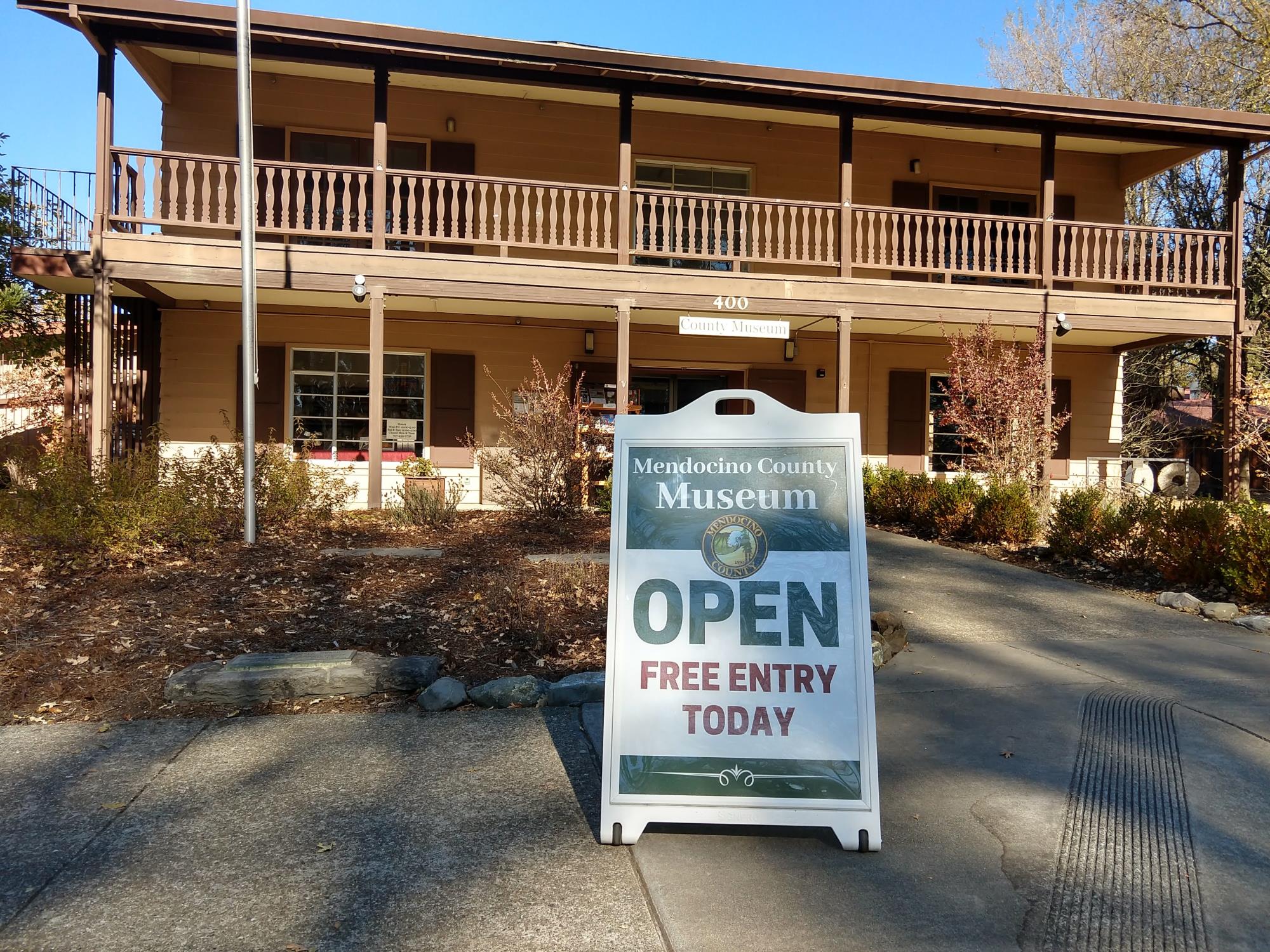 Two story building with open sign on sidewalk